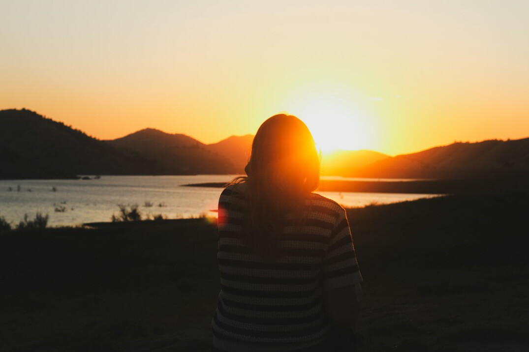 person looking at horizon at sunrise